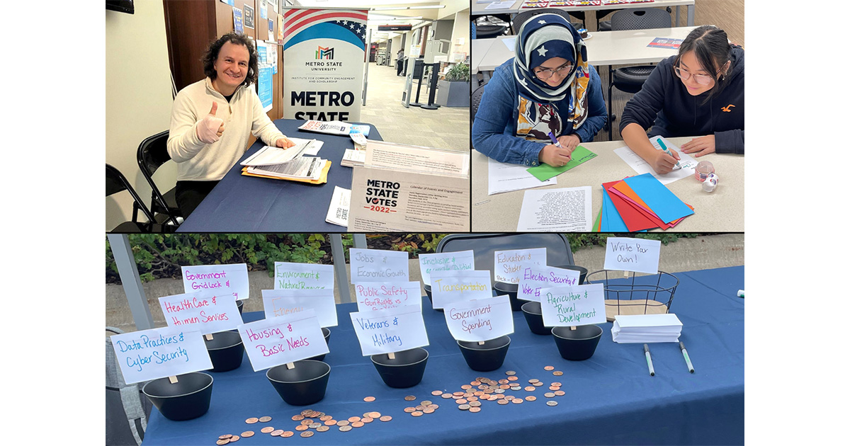 A man in a white sweater gives a thumbs up while sitting at a blue table, two women write letters, a blue table with black pots each holding a sign sits with pennies ilaying on the table in the foreground